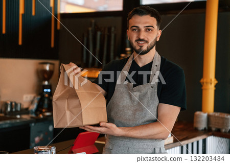 Your order is packaged and ready. Man is serving delicious street food 132203484