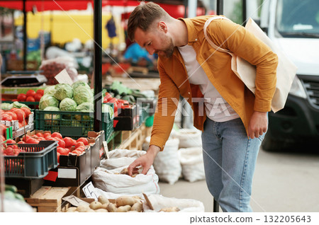 Handsome man is on the street market or bazaar Handsome man is on the street market or bazaar 132205643