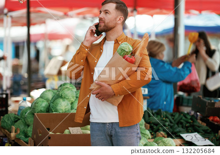 Handsome man is on the street market or bazaar Handsome man is on the street market or bazaar 132205684