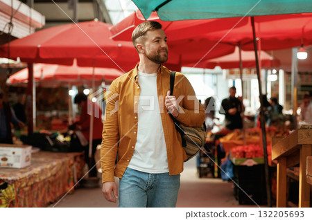 Going forward, looking at products. Handsome man is on the street market or bazaar 132205693
