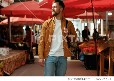 Front view, walking. Handsome man is on the street market or bazaar 132205694