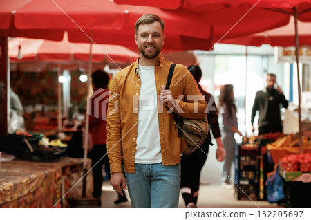 Front view, walking. Handsome man is on the street market or bazaar 132205697