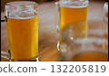 Cold beer partially poured on a wooden table Cold beer partially poured on a wooden table 132205819