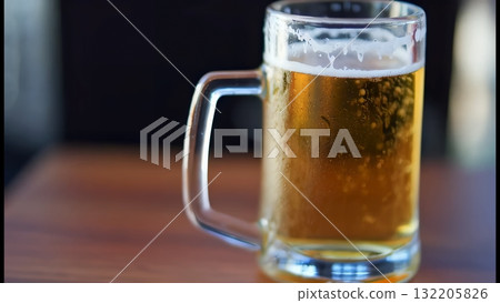 木桌上帶有泡沫和水滴的冷啤酒杯的特寫 132205826