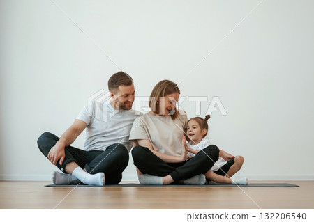 Family of mother, father and daughter are doing yoga at home Family of mother, father and daughter are doing yoga at home 132206540