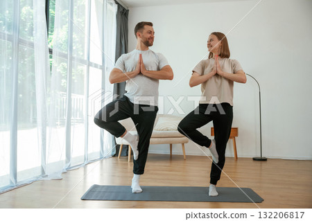 Man and woman are doing yoga exercises at home 132206817