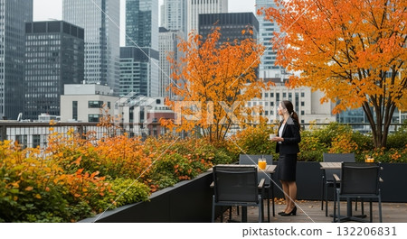 Woman enjoying autumn in the city on a terrace surrounded by autumn leaves 132206831