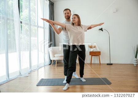 Man and woman are doing yoga exercises at home 132207027