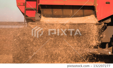 combine harvester working wheat field, agriculture wheat, farming business growing, combine wheat concept, harvest harvesting summer, red truck dumping grain. grain falling out back truck truck dirt combine harvester working wheat field, agriculture wheat, farming business growing, combine wheat concept, harvest harvesting summer, red truck dumping grain. grain falling out back truck truck dirt 132207277