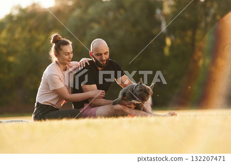 Man and woman are with dog on the field Man and woman are with dog on the field 132207471