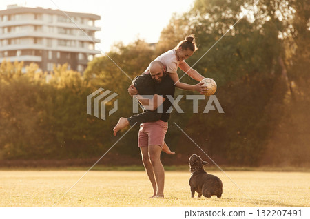 Girlfriend is with soccer ball. Man and woman are with dog on the field Girlfriend is with soccer ball. Man and woman are with dog on the field 132207491