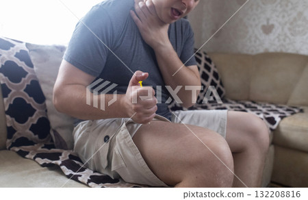 A man injects himself with adrenaline into his thigh during anaphylactic shock. First aid for allergies, emergency medical care for an allergic reaction. A man injects himself with adrenaline into his thigh during anaphylactic shock. First aid for allergies, emergency medical care for an allergic reaction. 132208816
