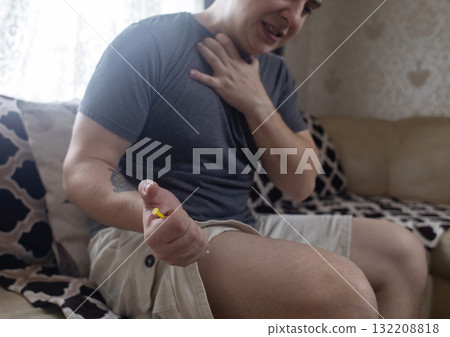A man injects himself with adrenaline into his thigh during anaphylactic shock. First aid for allergies, emergency medical care for an allergic reaction. A man injects himself with adrenaline into his thigh during anaphylactic shock. First aid for allergies, emergency medical care for an allergic reaction. 132208818