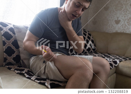 A man injects himself with adrenaline into his thigh during anaphylactic shock. First aid for allergies, emergency medical care for an allergic reaction. 132208819