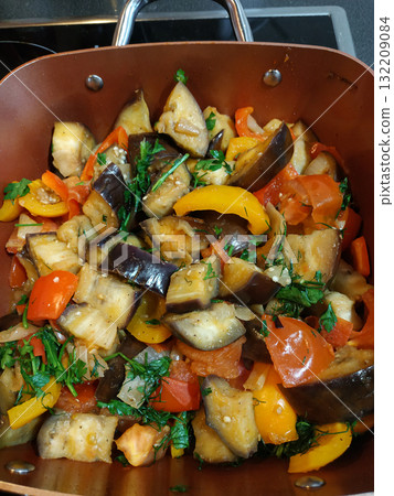 Sauteed eggplant, tomatoes, and peppers with fresh parsley in a pan healthy vegan dinner 132209084