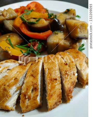 Sliced roasted chicken breast with sauteed eggplant, bell peppers, and herbs healthy dinner Sliced roasted chicken breast with sauteed eggplant, bell peppers, and herbs healthy dinner 132209093