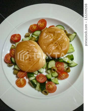 Delicious smoked cheeses served with fresh cherry tomatoes, cucumber, and olives salad Delicious smoked cheeses served with fresh cherry tomatoes, cucumber, and olives salad 132209208