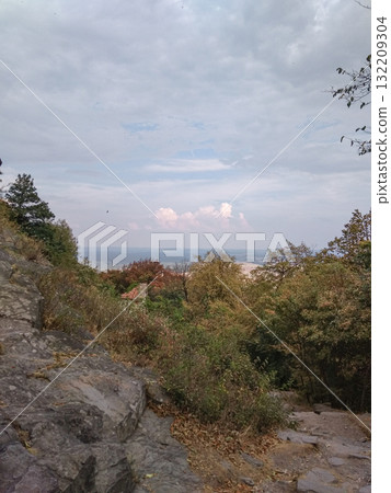Hiking trail descending through lush foliage overlooking machovo jezero and bezdez castle in czechia Hiking trail descending through lush foliage overlooking machovo jezero and bezdez castle in czechia 132209304