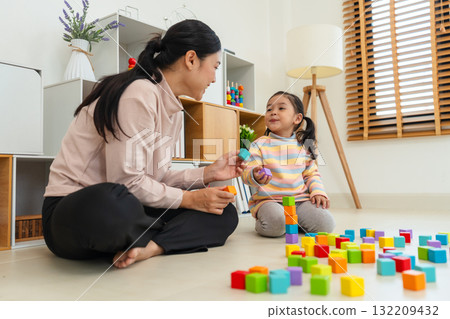 toddler girl playing wooden block toy cubes with her mother at home toddler girl playing wooden block toy cubes with her mother at home 132209432