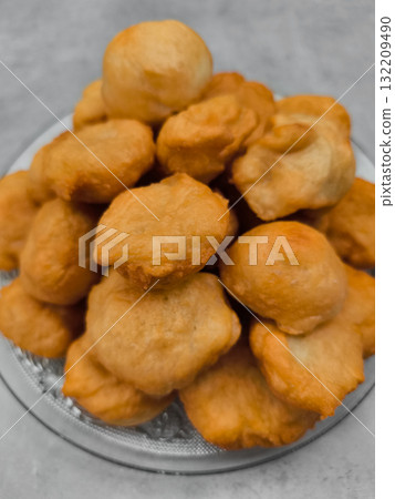 Freshly made baursaki piled high on glass plate in prague 132209490