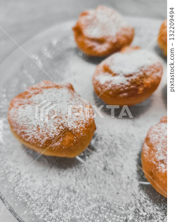 Delicious baursaki sprinkled with powdered sugar on glass plate in prague 132209494