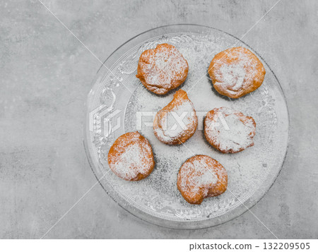 Delicious baursaki sprinkled with icing sugar on glass plate in prague copy space Delicious baursaki sprinkled with icing sugar on glass plate in prague copy space 132209505