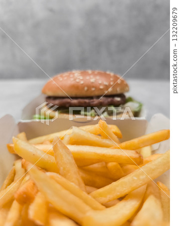 French fries and hamburger served in cardboard boxes on table galentines day French fries and hamburger served in cardboard boxes on table galentines day 132209679