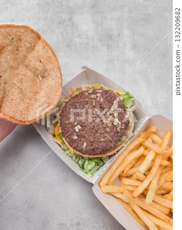 Opened burger with fries showing ingredients on gray background galentines day Opened burger with fries showing ingredients on gray background galentines day 132209682
