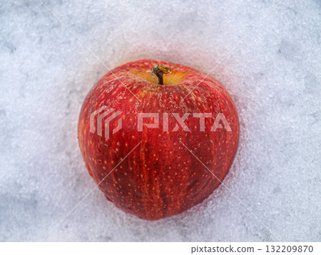 Red apple on the white snow. Top view. Copy space. Red apple on the white snow. Top view. Copy space. 132209870