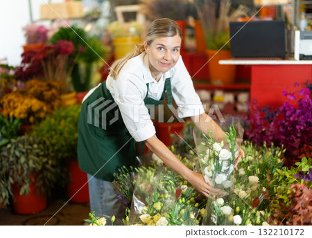 Florist creates bouquet of roses in flower shop 132210172