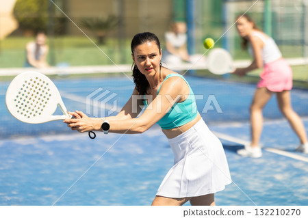 Woman on the court playing paddle tennis Woman on the court playing paddle tennis 132210270
