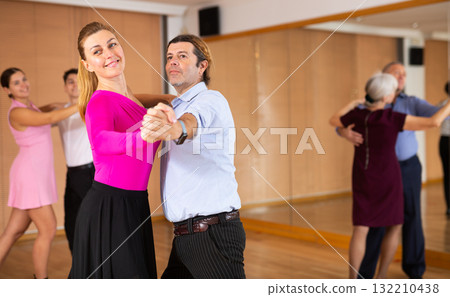 Couple of dancers rehearsing ballroom dances in dance studio Couple of dancers rehearsing ballroom dances in dance studio 132210438