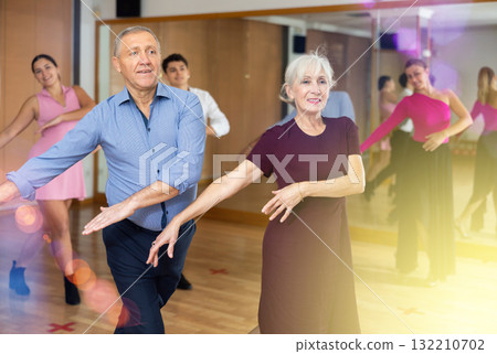 Elderly woman and man practicing jitterbug moves in dance studio 132210702