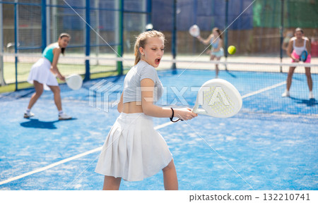 Young woman in sportswear playing paddle 132210741