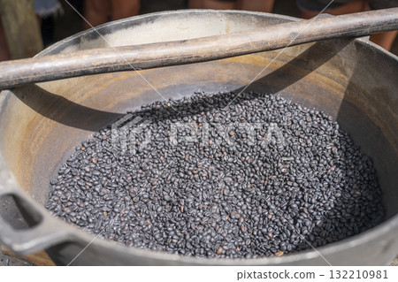 A bowl of dark roasted coffee beans outdoor at sunny day 132210981