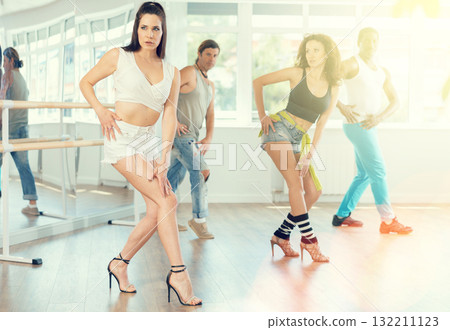 Female instructor performing expressive sass dance at group class 132211123