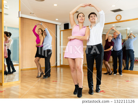 Young pair practicing ballroom dance in dance studio 132211126