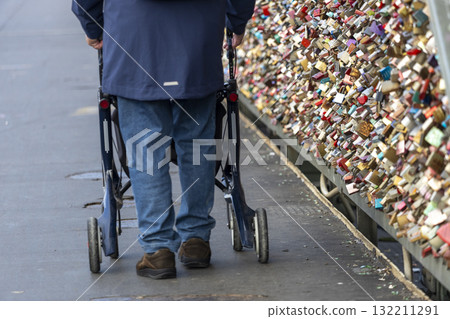 a man with rollators walk across the Hohenzollern Bridge, Cologne 132211291