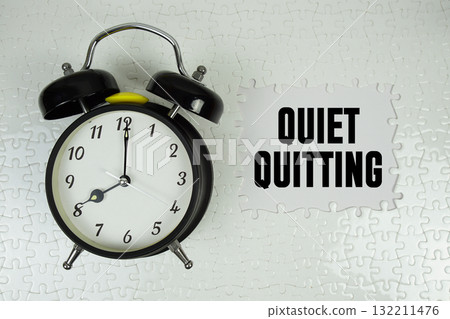 Jigsaw puzzle with a missing piece with "Quiet Quitting" and alarm clock on white background Jigsaw puzzle with a missing piece with "Quiet Quitting" and alarm clock on white background 132211476