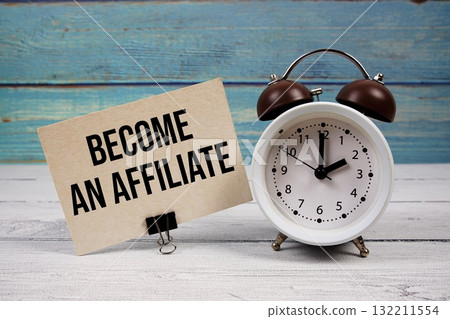 Become An Affiliate text written on paper card with alarm clock on wooden background 132211554