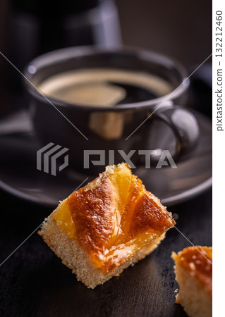 Catalana sponge cake and coffee cup on black table. Catalana sponge cake and coffee cup on black table. 132212460