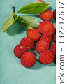 arbutus berries with leaves on a turquoise surface 132212637