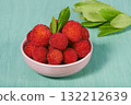 arbutus berries in a small pink bowl on turquoise 132212639