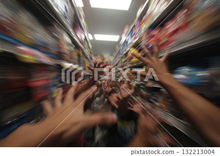 A blurry image of human hands reaching for items on supermarket shelves. 132213004