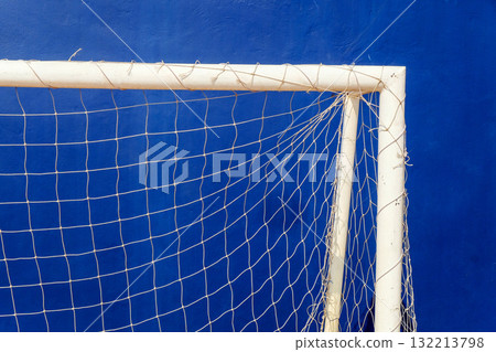 Close-up of a soccer goal net on a blue background. 132213798