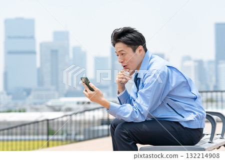 Man in work clothes, smartphone, laughing 132214908