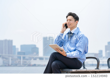 Man in work clothes making a phone call Tablet 132214940