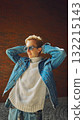 Smiling man in denim jacket enjoying sunlight with relaxed confidence 132215143