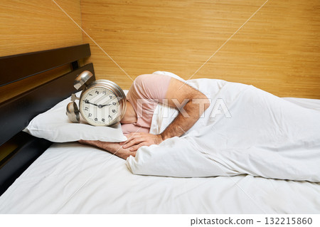Man with alarm clock instead of head sleeping in bed. Morning concept 132215860