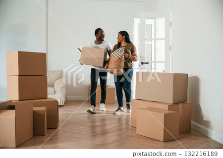 Walking in, holding boxes. African American couple are moving into new house Walking in, holding boxes. African American couple are moving into new house 132216189
